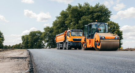 Vibratory asphalt rollers compactor and truckstanding on the side of the road. Road service build a new highway