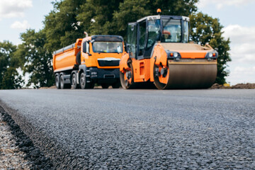 Vibratory asphalt rollers compactor and truckstanding on the side of the road. Road service build a new highway	
