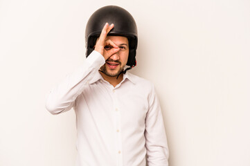 Hispanic business man going to work with motorcycle isolated on white background excited keeping ok gesture on eye.