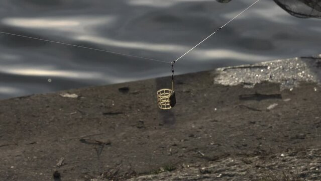 Fishing basket, feder basket for fishing from the ground hanging from the fishing line on the rod.