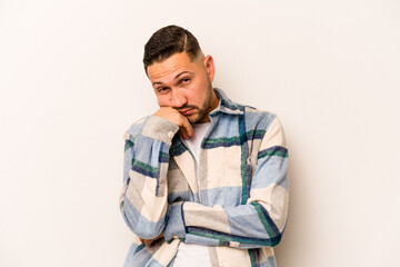 Young hispanic man isolated on white background tired of a repetitive task.