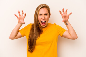 Young caucasian woman isolated on white background showing claws imitating a cat, aggressive...