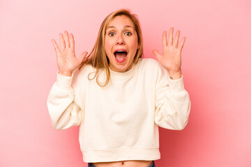 Young caucasian woman isolated on pink background receiving a pleasant surprise, excited and...