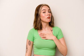 Young caucasian woman isolated on white background taking an oath, putting hand on chest.