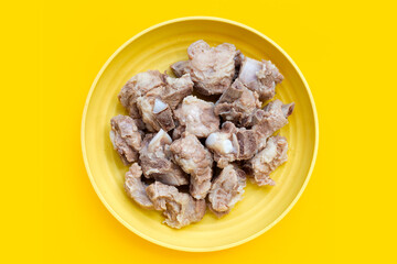 Boiled pork ribs on yellow background.