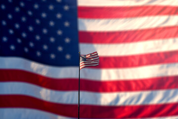 Concept photo of the flag of America winding against a blurry background with another USA flag.