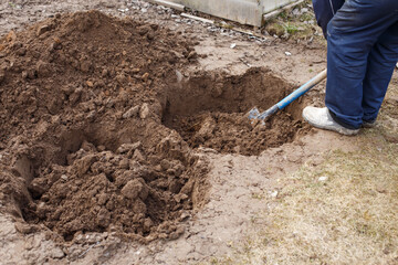 man digging a hole for planting a fruit tree in the garden