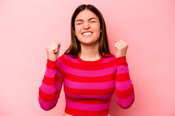 Young caucasian woman isolated on pink background celebrating a victory, passion and enthusiasm, happy expression.