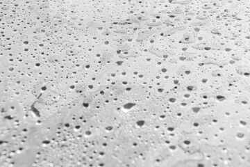 Drops on glass as abstract blue background. Pattern of misted polyethylene after rain. Agricultural cellophane film for packing is covered with large number of water jet