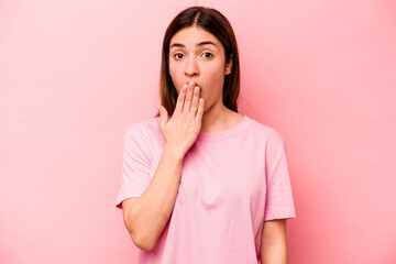 Young caucasian woman isolated on pink background shocked, covering mouth with hands, anxious to discover something new.