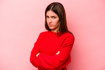 Young caucasian woman isolated on pink background suspicious, uncertain, examining you.