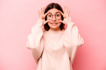 Young caucasian woman isolated on pink background keeping eyes opened to find a success opportunity.
