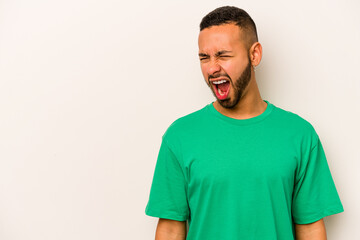 Young hispanic man isolated on white background shouting very angry, rage concept, frustrated.
