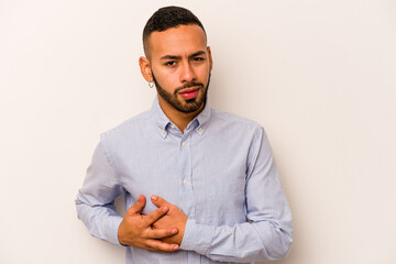Young hispanic man isolated on white background having a liver pain, stomach ache.