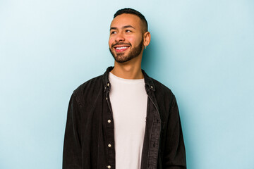 Fototapeta Young hispanic man isolated on blue background relaxed and happy laughing, neck stretched showing teeth. obraz