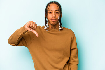 Young African American man isolated on blue background showing a dislike gesture, thumbs down....