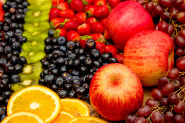 Fresh fruits concept, Arrangement of kiwi orange apple and assorted burry as background