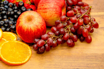 Naklejka na ściany i meble Fresh fruits concept, Healthy fruits consist of grapes apple orange and berry on wooden background