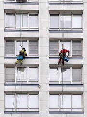 Industrial climbers wash windows on huge residential building. Working at height requires skills and abilities.
