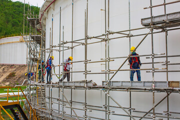 Architect on site construction workers on a scaffold tank oil