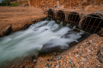 Culvert flowing industrial water slow motion out in release into the sea