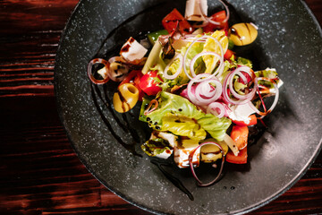 Vegetable salad with olives, onions, herbs and cheese top view.