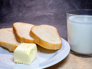 Pieces of rye and white bread with a glass of milk on a plate. Healthy breakfast. Bakery products