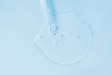 Cosmetic oil, serum or serum and pipette on a light blue background. Medicine, beauty and health concept