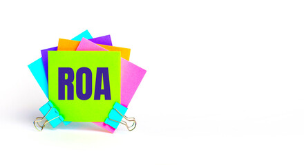 There are bright multi-colored stickers with the text ROA Return On Assets. Copy space