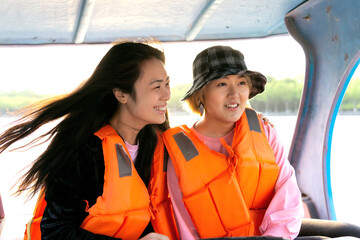 Fototapeta na wymiar Two Asian Girls in Happy Moment Having Fun Outdoors on Boat.