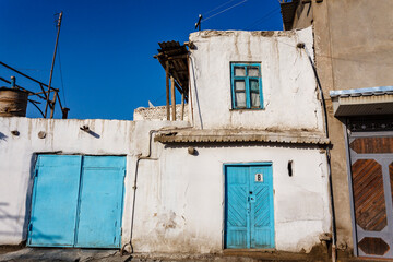 Facade of a white house with light blue windows and door in Bukhara, Uzbekistan, Central Asia