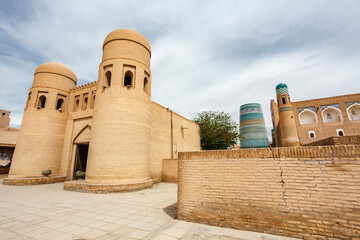 View at an old madrasa and Kalta Minor minaret in the old town of Khiva, Uzbekistan, Central Asia