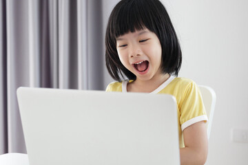 little asian girl student study online using laptop computer at home