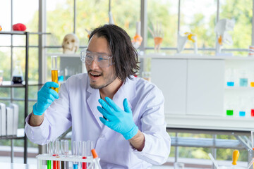 Portrait of Asian smart man scientist holds test tube in laboratory. The scientist is smiling, he...