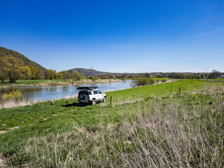 Offroad vehicle in a field by a river