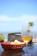 夏の屋外で飲む、よく冷えた白ワインのグラス