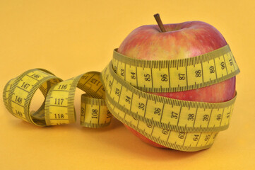 Pomme entouré d'un mètre souple sur fond jaune