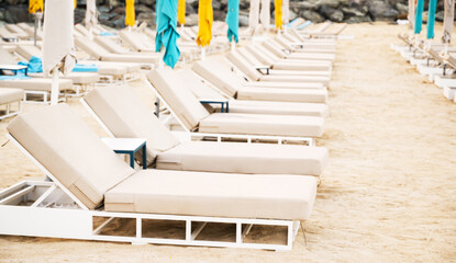 Empty sun loungers on the sandy beach . Vacation nesar sea or ocean concept