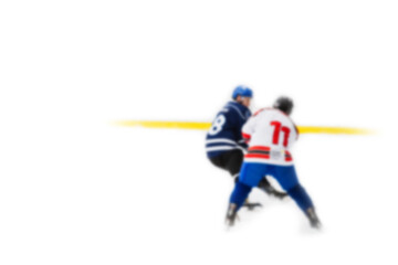 Rival hockey players fight for control of the puck - out of focus hockey player on ice - blur...