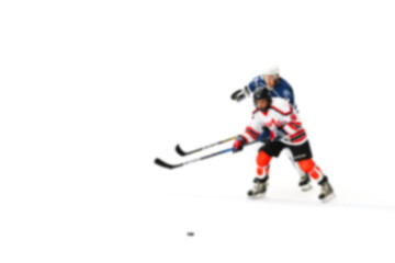 Rival hockey players fight for control of the puck - out of focus hockey player on ice - blur...