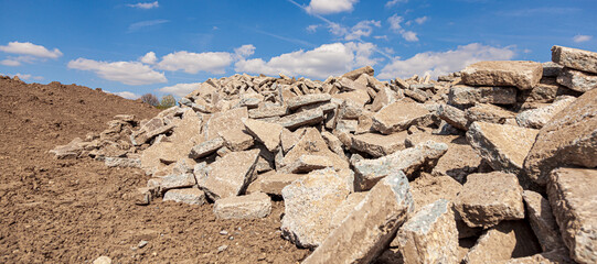 concrete debris piles on the ground in vineyards area nature with cloudy sky. large pile of...