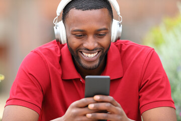 Happy man with black skin listening to music in a bar