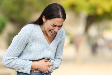 Woman suffering belly ache complaining in the street
