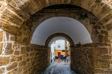 A view through a tunnel entrance below the city walls in the old quarter of Cadiz on a spring day