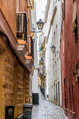 Fototapeta na wymiar A view down a narrow street in the city of Cadiz on a spring day