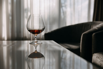 Glass of cognac on a table in daylight.