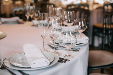 Closeup of a table setting in restaurant with glasses and plates.