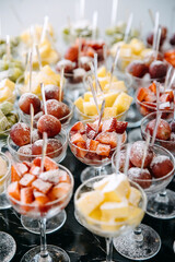 Various fresh fruits and berries in glasses at a party reception.