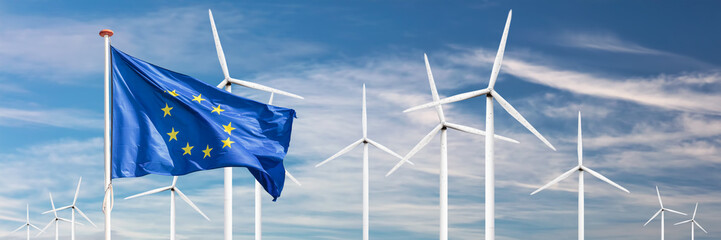 Flag of the European Union in front of a large windpark with wind turbines - 499830072