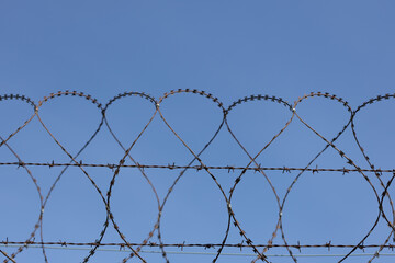 barbed wire against the blue sky